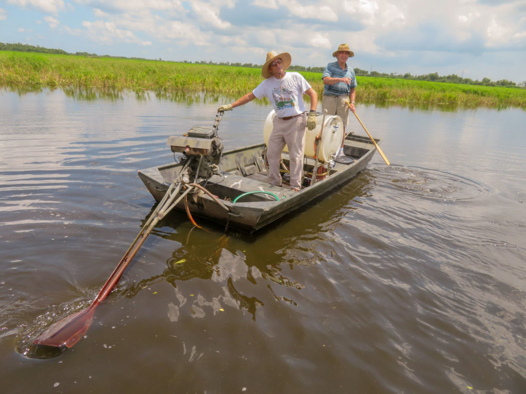 Two cajun men in an aluminum boat, land owners where our air boat swamp tour was offered.  OurTravelCafe.com