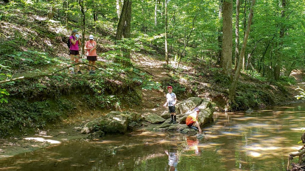 A family plays near a mountain stream