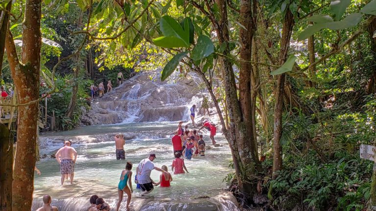 Tourists climbing waterfall in Jamaica